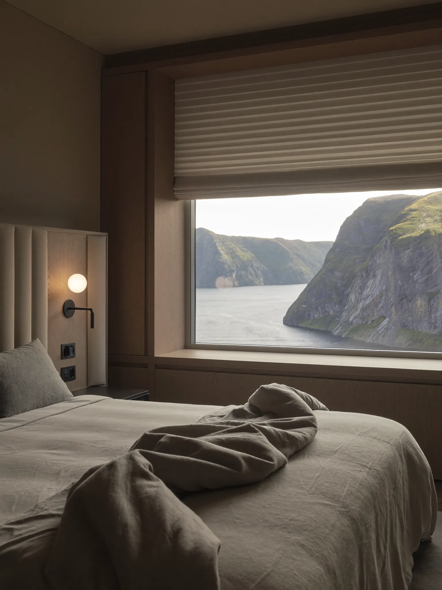 Zimmer im NORDHAUS mit Leinenbett und Blick auf die Steilküste